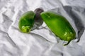 Two green hot jalapenos pepper one big and one small